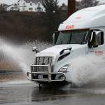 A semi truck sprays water as it drives along a flooded Marine View Drive on Tuesday, Dec. 27, 2022 in Everett, Washington. (Olivia Vanni / The Herald)