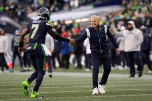 Seattle Seahawks quarterback Geno Smith (7) and head coach Pete Carroll shake hands during an NFL football game against the Las Vegas Raiders, Sunday, Nov. 27, 2022, in Seattle, WA. The Raiders defeated the Seahawks 40-34. (AP Photo/Ben VanHouten)