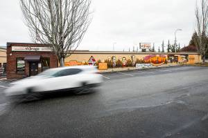 A car drives past a large mural covering the wall of the Everett Downtown Storage on Monday, Dec. 26, 2022. (Olivia Vanni / The Herald)