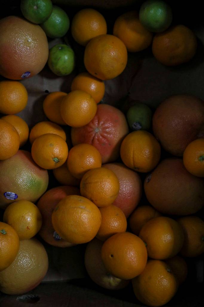 Citrus fruit at the Edmonds Food Bank in Edmonds, on Jan. 16. Scriber Lake High School student Juniper works at the food gank as part of an on-the-job training class that teaches students about career options and goal planning, while also paying them for a part-time internship. (Annie Barker / The Herald)