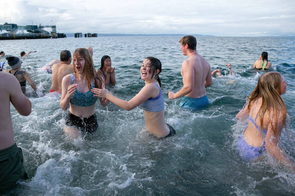 Brave plungers turn to retreat for dry land after getting a taste of the cold ocean waters during the 2023 Edmonds Polar Bear Plunge on Sunday, Jan. 1, 2023, at Bracketts Landing in Edmonds, Washington. (Ryan Berry / The Herald)