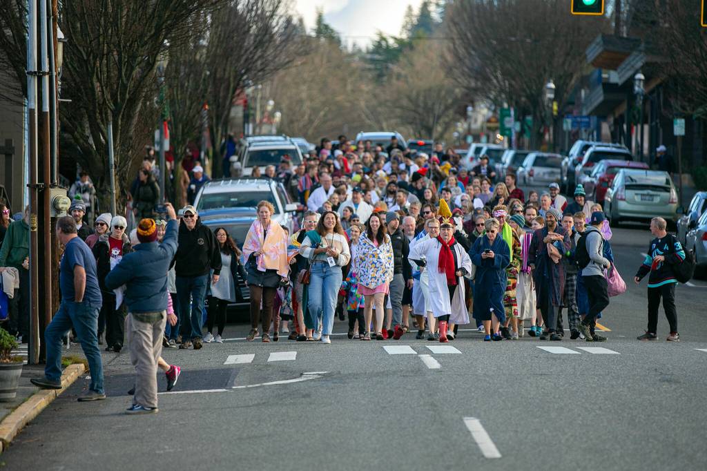 Plungers march down Main Street as they head for the waterfront during the 2023 Edmonds Polar Bear Plunge on Sunday, Jan. 1, 2023, at Bracketts Landing in Edmonds, Washington. (Ryan Berry / The Herald)