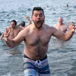 A plunger emerges from the water hyped up and freezing during the 2023 Edmonds Polar Bear Plunge on Sunday, Jan. 1, 2023, at Brackett’s Landing in Edmonds, Washington. (Ryan Berry / The Herald)