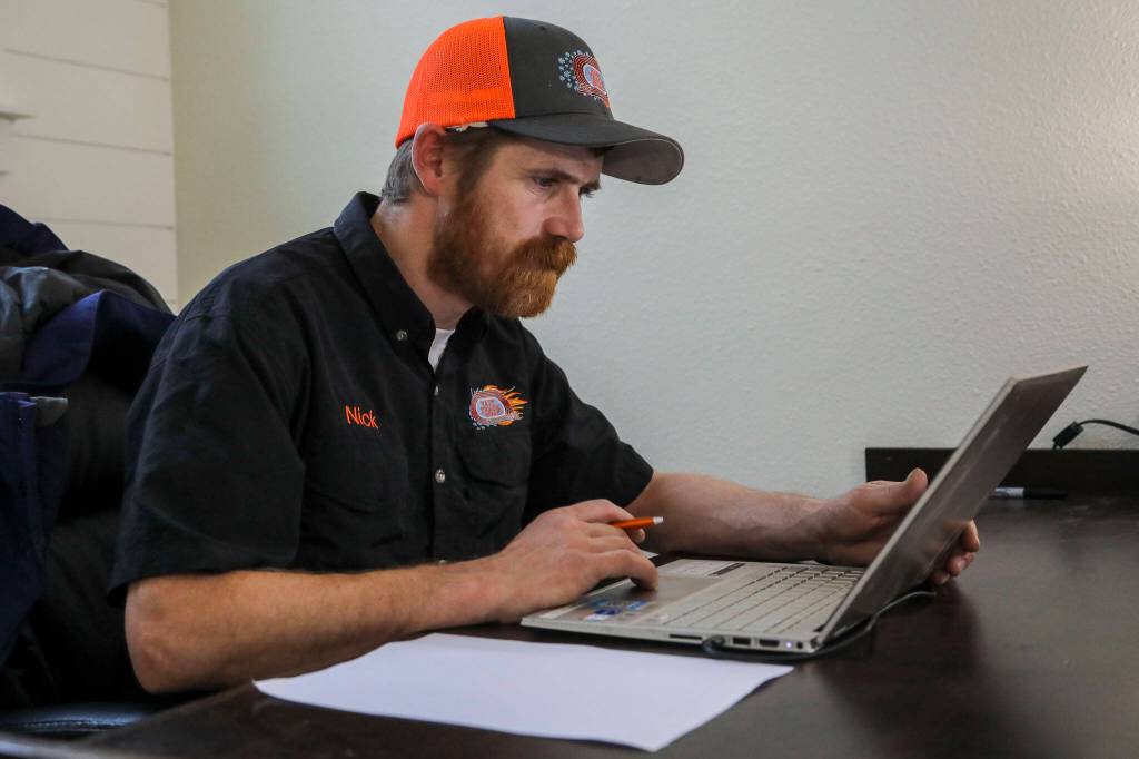Nick Cairus, 38, works at his desk at Fast Track Hvac in Stanwood on Monday. Nick Cairus and Patricia Cairus lost their housing in the recession and were homeless for a number of years. They started a successful HVAC company during the pandemic in a former newspaper printing building. (Annie Barker / The Herald)