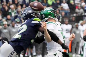 Seattle Seahawks defensive end Darrell Taylor, left, forces New York Jets quarterback Mike White (5) to fumble during the first half of Sundays game in Seattle. The Seahawks recovered the ball. (AP Photo/Ted S. Warren)