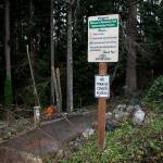 A sign for Veterans Memorial Park indicates no access to the transit center on Jan. 9, in Mountlake Terrace. The city plans to pave a path that complies with the Americans with Disabilities Act and install lighting. (Olivia Vanni / The Herald)