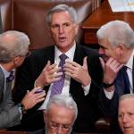 Rep. Patrick McHenry, R-N.C., (left) and Rep. Tom Emmer, R-Minn., (right) speak with Rep. Kevin McCarthy, R-Calif., in the House chamber as the House meets for a second day to elect a speaker and convene the 118th Congress in Washington, D.C., Wednesday. (Alex Brandon / Associated Press)