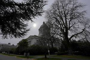 The sun appears through cloudy skies Thursday, March 10, 2022, above the Legislative Building at the Capitol in Olympia, Wash. Washington lawmakers were wrapping up their work Thursday with final votes on a supplemental state budget and a transportation revenue package before planning to adjourn the legislative session. (AP Photo/Ted S. Warren)