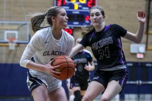 Glacier Peak’s Kylani Rookstool (1) and Lake Stevens’ Kamryn Wenz (24) fight for the ball during a game between the Lake Stevens Vikings and Glacier Peak Grizzlies at Glacier Peak High School on Friday, Jan. 6, 2023. The Grizzlies won, 51-32. (Annie Barker / The Herald)
