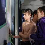 Swimmers look at the race schedule during the Jackson vs. Kamiak boys swim and dive meet at West Coast Aquatics in Mill Creek, Washington on Tuesday Jan. 10, 2023. (Annie Barker / The Herald)