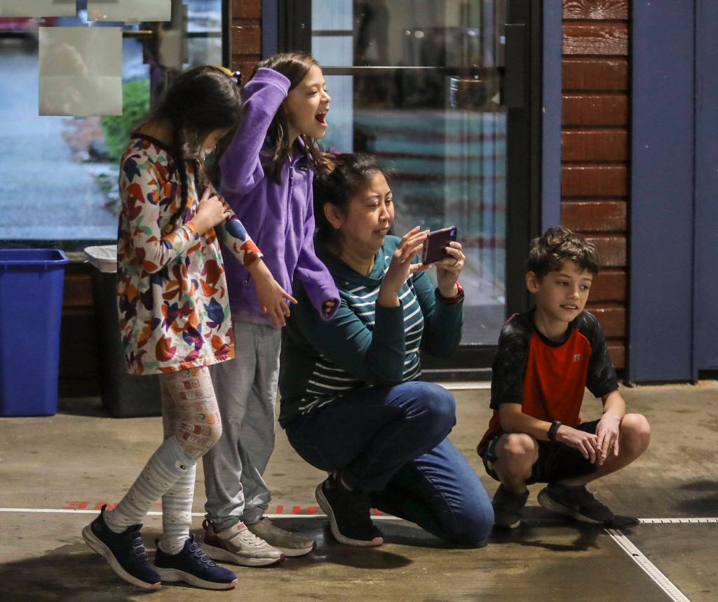 Attendees cheer and watch during the Jackson vs. Kamiak boys swim and dive meet at West Coast Aquatics in Mill Creek, Washington on Tuesday Jan. 10, 2023. (Annie Barker / The Herald)