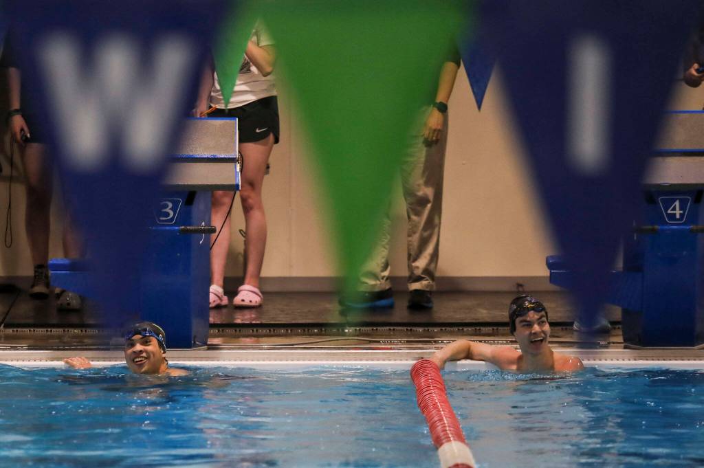 Jacksons Ethan Chen-Park, left, and Kamiaks Jack Fast, right, react after placing first and second in the fifth heat of the 50 yard freestyle race during the Jackson vs. Kamiak boys swim and dive meet at West Coast Aquatics in Mill Creek, Washington on Tuesday Jan. 10, 2023. (Annie Barker / The Herald)