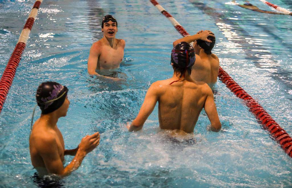 Kamiaks Jack Fast, left, looks at the time clock board during the Jackson vs. Kamiak boys swim and dive meet at West Coast Aquatics in Mill Creek, Washington on Tuesday Jan. 10, 2023. (Annie Barker / The Herald)