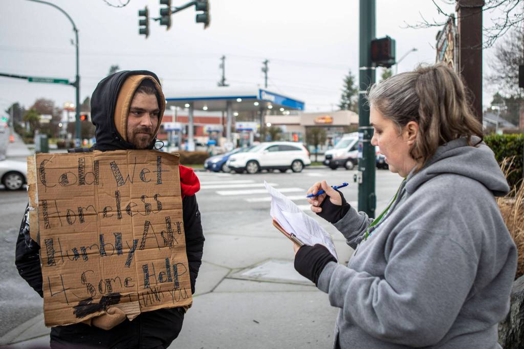 Catholic Community Services NW Director of Housing Services and Everett Family Center Director Rita Jo Case, right, speaks to a man who asked to remain anonymous, left, during a point-in-time count of people facing homelessness on Tuesday, in Everett. (Annie Barker / The Herald)