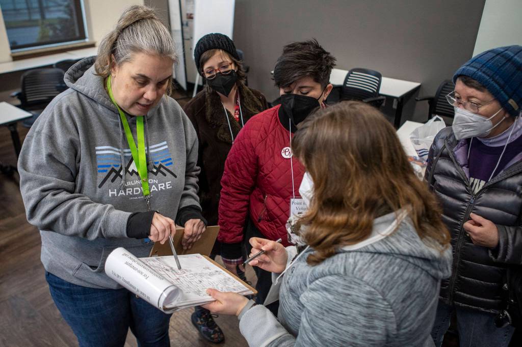 Catholic Community Services NW Director of Housing Services and Everett Family Center Director Rita Jo Case, left, instructs volunteers on where to go during a point-in-time count of people facing homelessness on Tuesday, in Everett. (Annie Barker / The Herald)