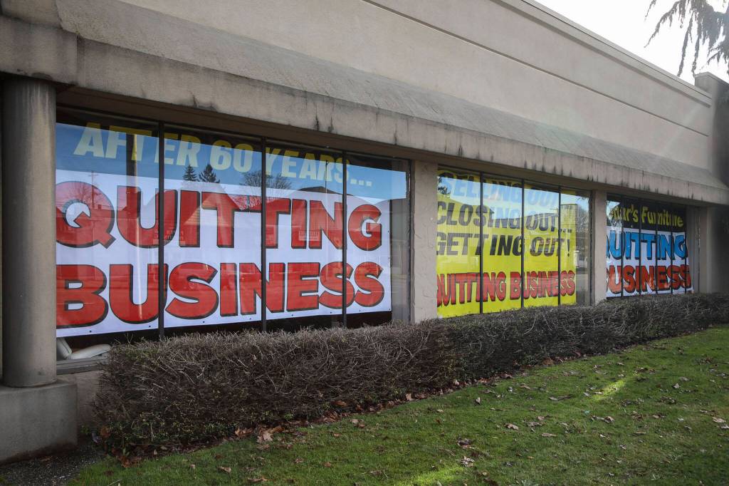 Closing signs are posted in the windows at Behars Furniture on Monday. Behars Furniture on Broadway in Everett is closing up shop after 60 years in business. The family-owned furniture store opened in 1963, when mid-century model styles were all the rage. Second-generation owner, Jay Behar says its time to move on. (Annie Barker / The Herald)
