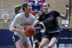 Glacier Peak’s Kylani Rookstool (1) and Lake Stevens’ Kamryn Wenz (24) fight for the ball during a game between the Lake Stevens Vikings and Glacier Peak Grizzlies at Glacier Peak High School on Friday, Jan. 6, 2023. The Grizzlies won, 51-32. (Annie Barker / The Herald)