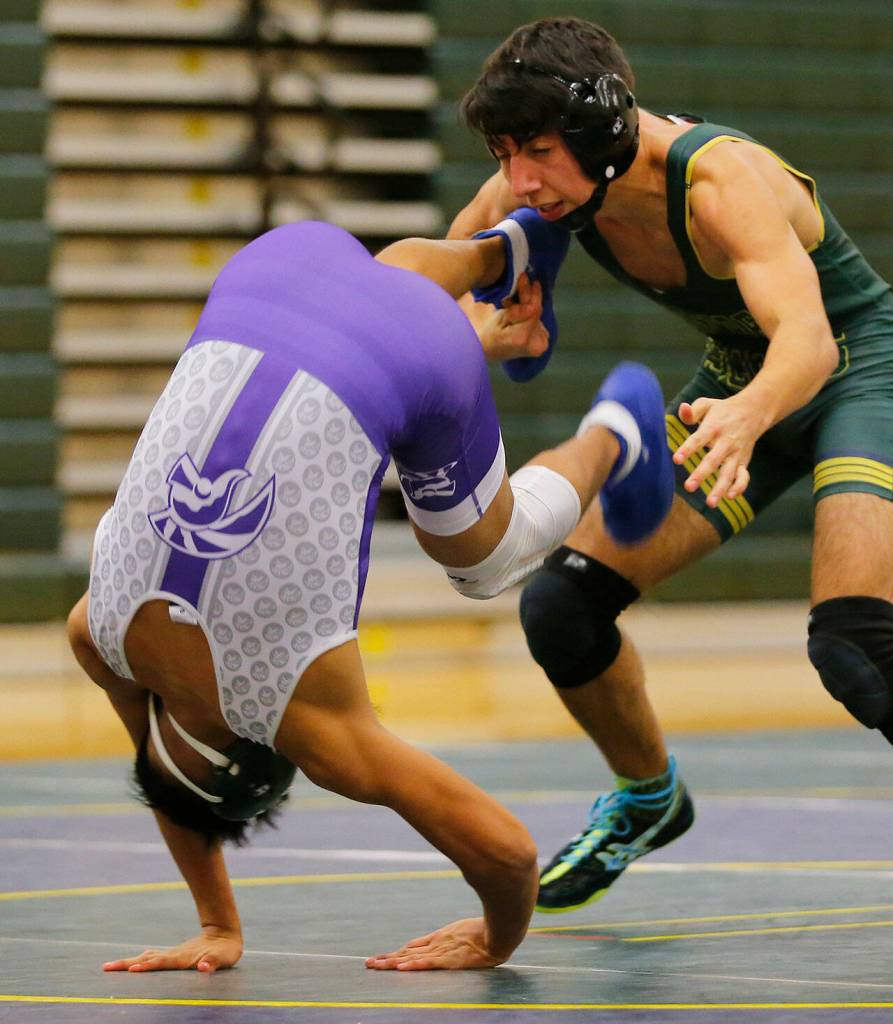 Edmonds-Woodways Joseph Martinez somersaults away from Shorecrests Brian Ramirez on Wednesday, Jan. 18, 2023, at Shorecrest High School in Shoreline, Washington. (Ryan Berry / The Herald)