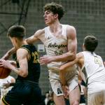 Arlingtons David Zachman reaches over the shoulder of Shorecrests Parker Baumann and fouls him during the game on Thursday, Jan. 19, 2023 in Arlington, Washington. (Olivia Vanni / The Herald)