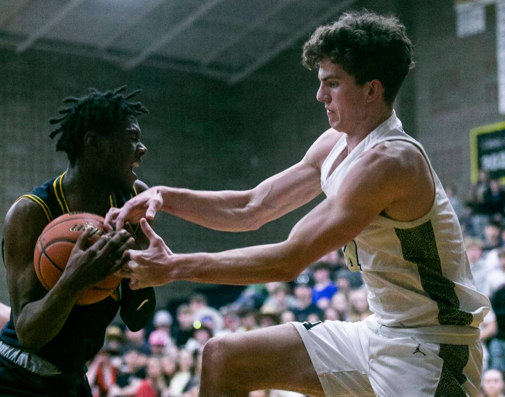 Arlingtons David Zachman tries to grab the ball from Shorecrests Disma Kagarabi during the game on Thursday, Jan. 19, 2023 in Arlington, Washington. (Olivia Vanni / The Herald)
