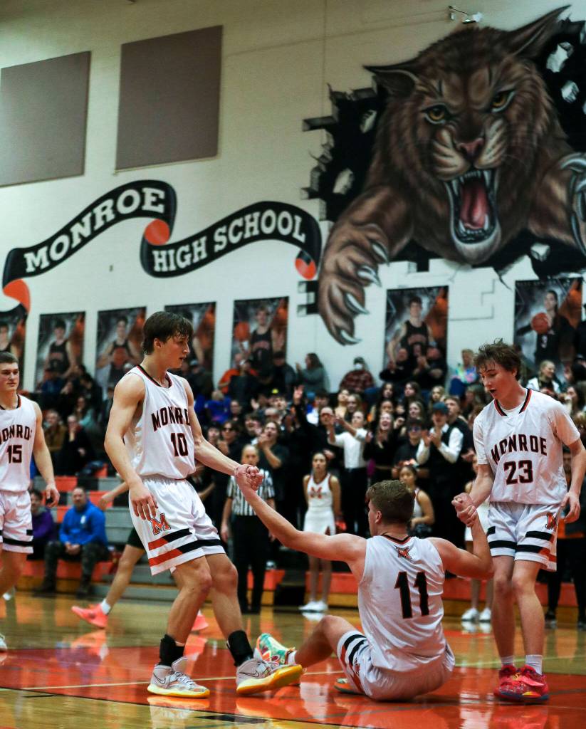 Monroes Reid Schaeffer (11) is helped up by his teammates during a game between the Monroe Bearcats and the Edmonds-Woodway Warriors at Monroe High School in Monroe, on Jan. 20. The Bearcats defeated the Warriors, 68-57. (Annie Barker / The Herald)
