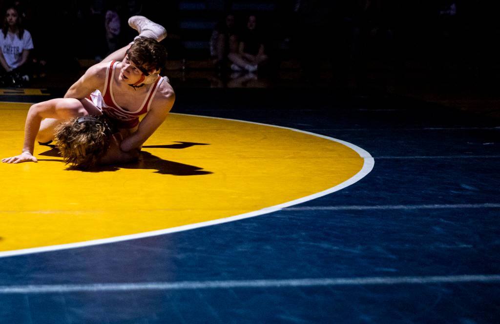Stanwoods Bryan Roodzant looks up to his coach the during the 126 pound weight class match on Tuesday, Jan. 24, 2023 in Arlington, Washington. (Olivia Vanni / The Herald)