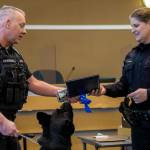 Sgt. Jason Robinson, left, and K-9 Hobbs receive a medal from Edmonds Police Chief Michelle Bennett during Hobbs retirement ceremony at the Edmonds Police Department on Thursday, in Edmonds. (Annie Barker / The Herald)