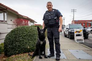 K-9 Hobbs and Sgt. Jason Robinson pose for a photo after Hobbs’ retirement ceremony at the Edmonds Police Department in Edmonds, Washington on Thursday Jan. 26, 2023. (Annie Barker / The Herald)