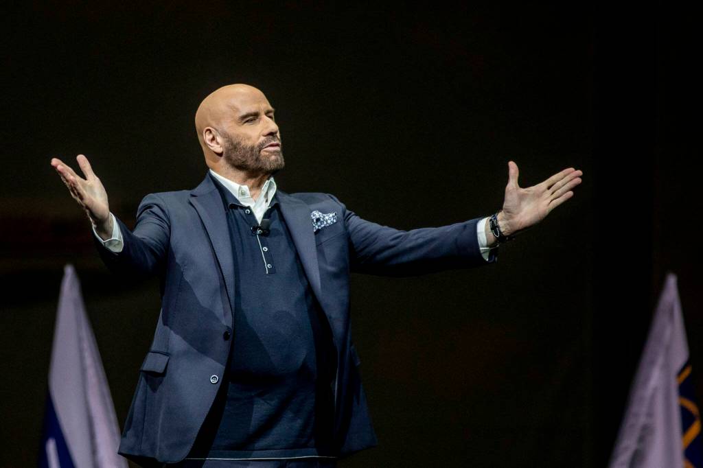 John Travolta speaks during a celebration event on Tuesday, at the 747 factory in Everett. Travolta is a pilot and did the voiceover for the videos on display. (Annie Barker / The Herald)