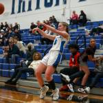 ECs Raylie Wardenaar (3) shoots the ball as ECCs Mia Jones (11) falls into a fan during a womens game between the Everett Community College Trojans and Edmonds College Tritons at Seaview Gymnasium at Edmonds College in Lynnwood, Washington on Wednesday Jan. 25, 2023. The Tritons won, 65-52. (Annie Barker / The Herald)