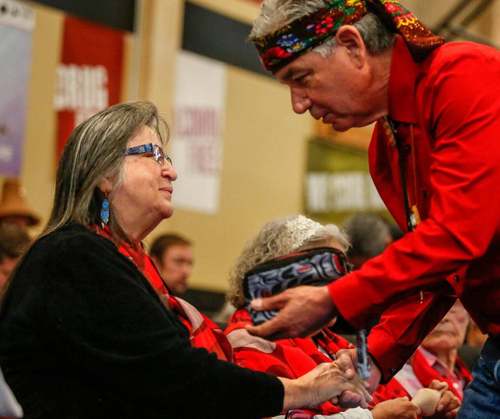 Tulalip Tribes Board Treasurer and event speaker Les Parks makes a presentation Wednesday, honoring Eleanor Nielsen, who was among grandmothers celebrated at Tulalip. Nielsen said, I always wanted to be a little old lady because they were the sweetest, the smartest, and had the best stories. Parks was the person who, when women recently became the majority, made a motion to the new board to designate a Year of the Woman, beginning with this event. (Dan Bates / The Herald)