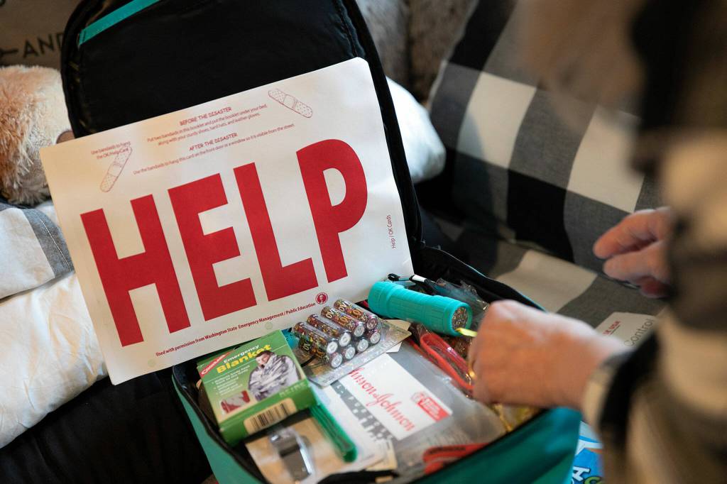 Gail Thompson opens a backpack of emergency supplies that she keeps at her home in Oso. (Ryan Berry / The Herald)