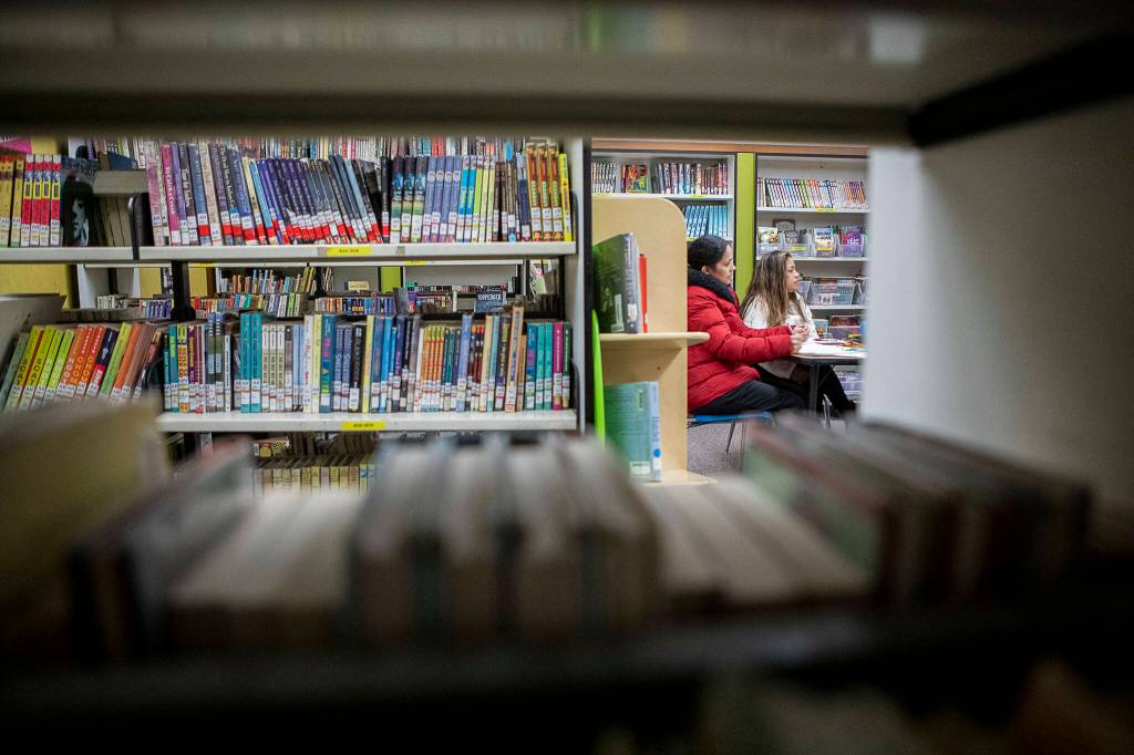 Anayeli Granados, left, and Carmen Roldain, right, listen as Maricel Pe Samaniego teaches English at Liberty Elementary School on Jan. 30, in Marysville. Marysville schools partners with EvCC to offer free English classes to parents of multi-lingual students. (Annie Barker / The Herald)