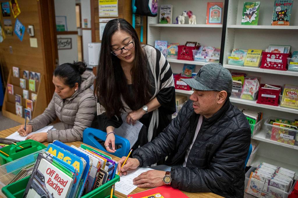 Maricel Pe Samaniego, center, teaches English to Liedith Espana, left, and Nemecio Rios, right, at Liberty Elementary School ON JAN. 30, in Marysville. Marysville schools partners with EvCC to offer free English classes to parents of multi-lingual students. (Annie Barker / The Herald)