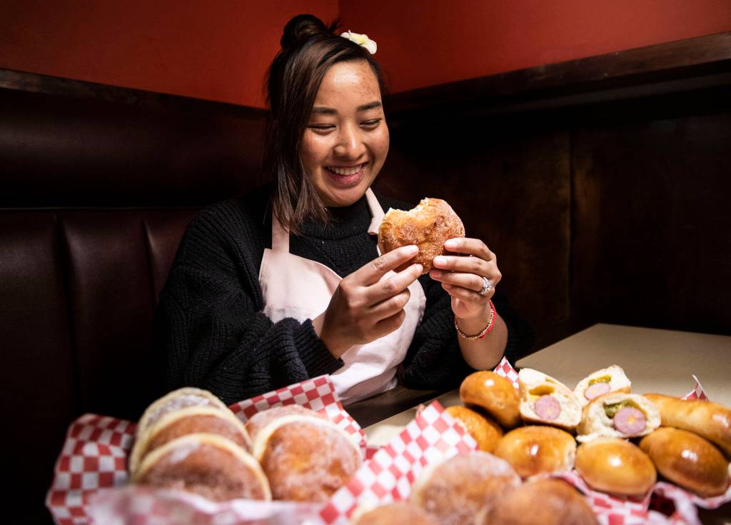 Alice Tum shows an assortment of the malasadas and kolaches she made at Bobbys Hawaiian Style Restaurant in March 2022. (Olivia Vanni / The Herald)