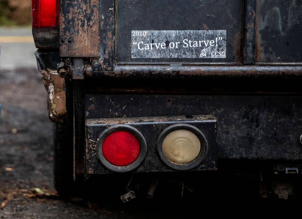 A Carve or Starve! bumper sticker is visible on the back of the truck Steve Backus uses for work. (Olivia Vanni / The Herald)