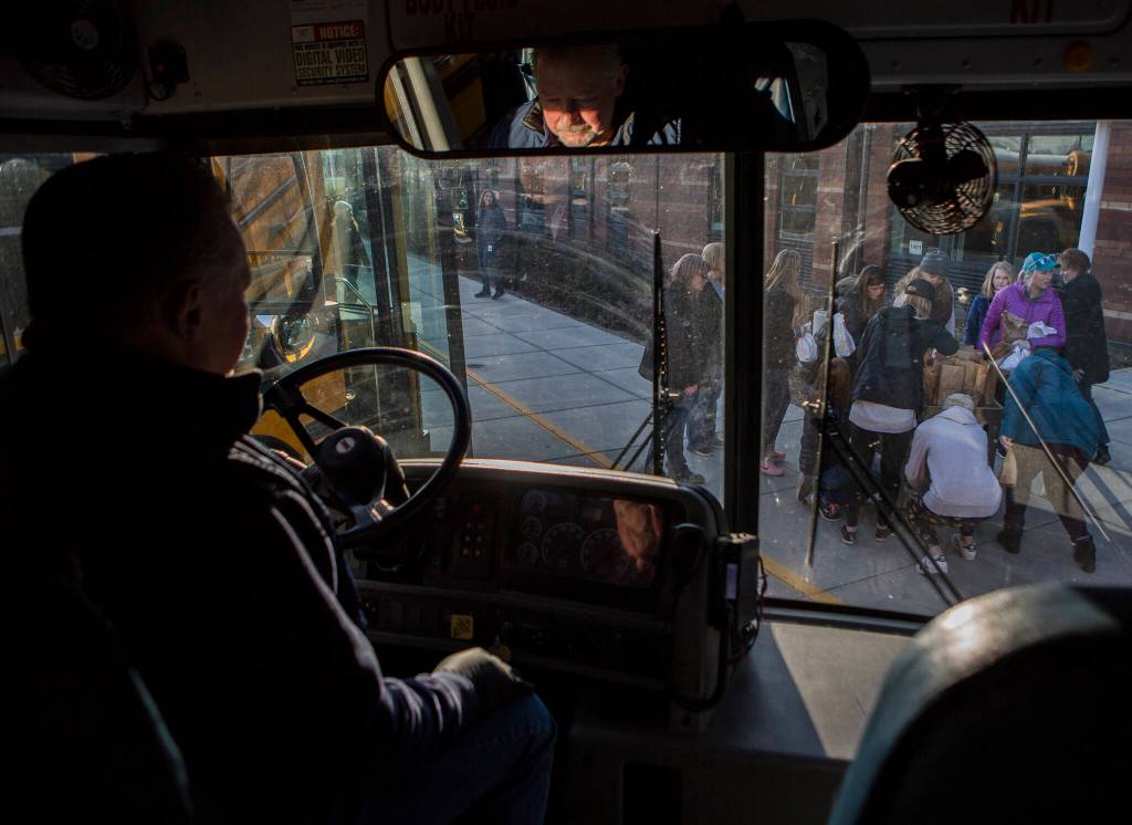 People gather to pick up special allergy meals before leaving Lakewood High School on March 18, 2020 in Marysville. (Olivia Vanni / The Herald)