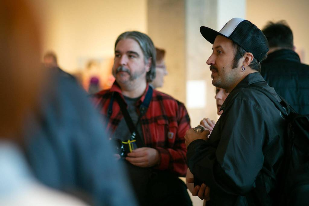 Artist Sashko Danylenko, right, whose art is featured in the gallery, mingles with guests during a public event highlighting the For Ukraine: Art of Freedom exhibit at the Schack Art Center on Saturday, in downtown Everett. (Ryan Berry / The Herald)
