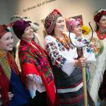 Members of the Ukrainian Association of Washington State take photos with guests during a public event highlighting the For Ukraine: Art of Freedom exhibit at the Schack Art Center on Saturday, in downtown Everett. (Ryan Berry / The Herald)