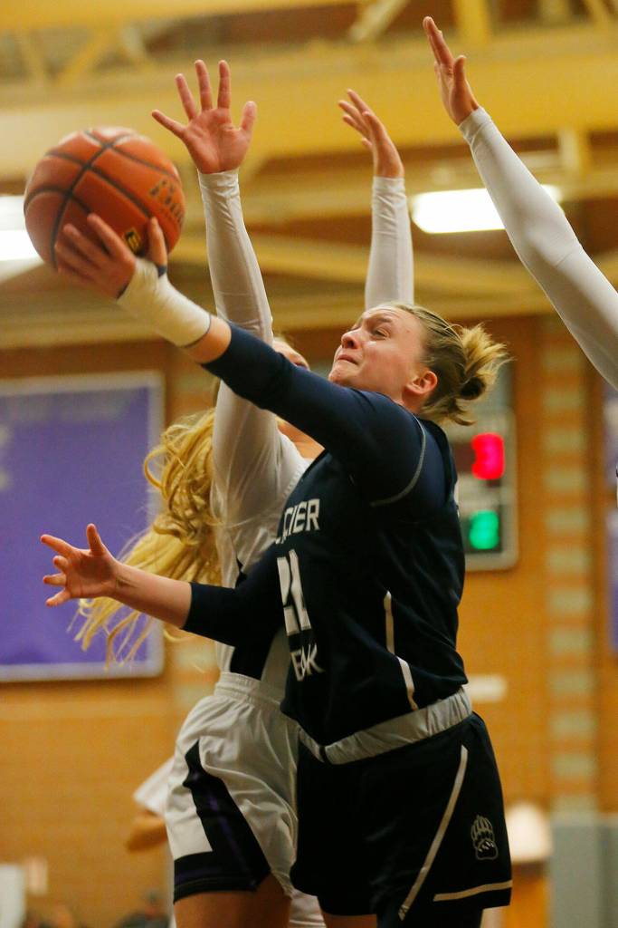 Glacier Peaks Zoey Ritter gets past two defenders to score on a layup against Kamiak on Wednesday, Feb 1, 2023, at Kamiak High School in Mukilteo, Washington. (Ryan Berry / The Herald)