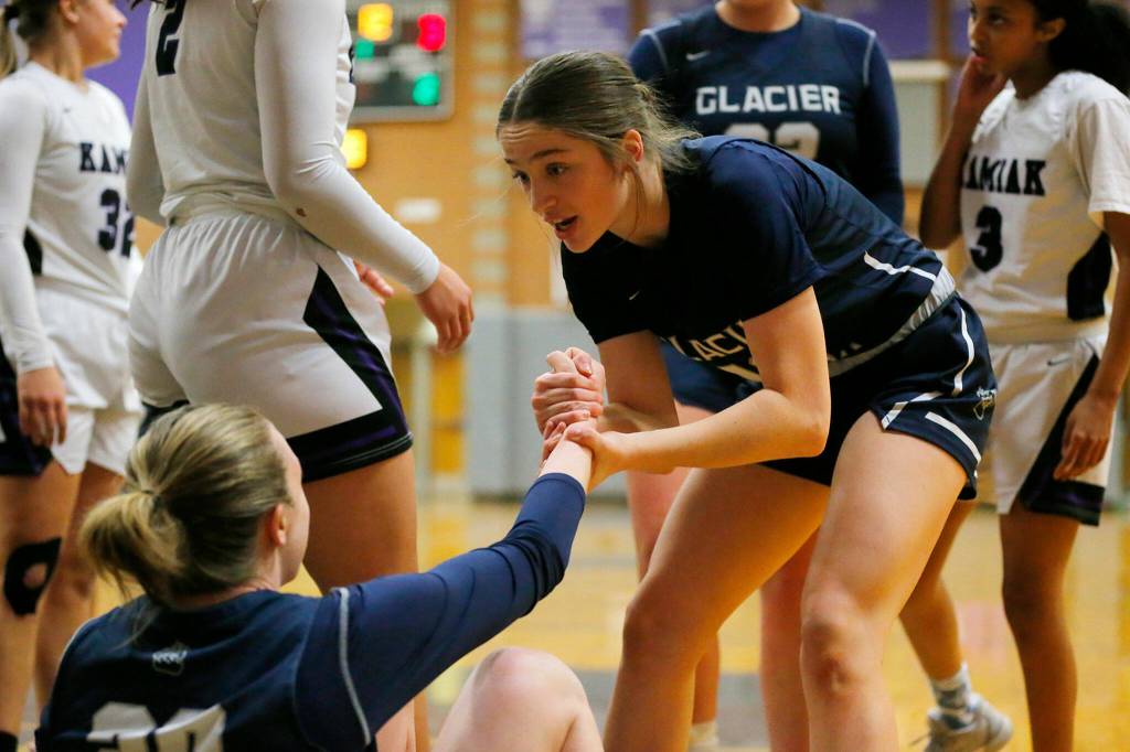 Glacier Peaks Sammie Thoma helps up teammate Zoe Ritter after a score against Kamiak on Wednesday, Feb 1, 2023, at Kamiak High School in Mukilteo, Washington. (Ryan Berry / The Herald)