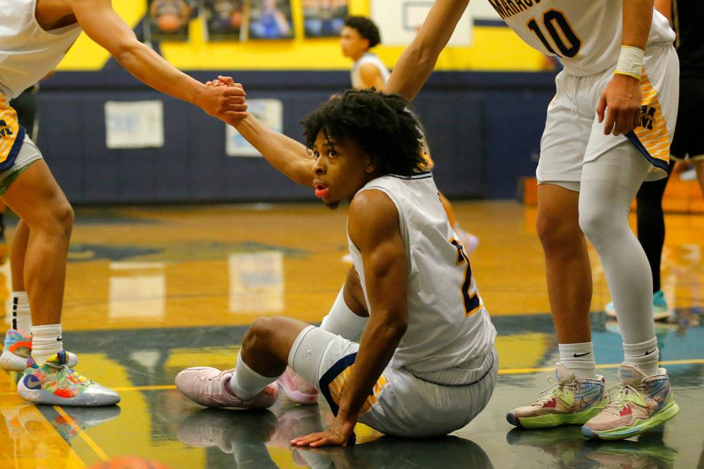 Mariners Jailin Johnson gets helped up by teammates after drawing an offensive foul against Lake Stevens on Thursday, Feb. 2, 2023, at Mariner High School in Everett, Washington. (Ryan Berry / The Herald)