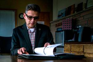 Arif Ghouseat flips through his work binder in his office conference room Paine Field on Monday, Dec. 10, 2018 in Everett, Wa. (Olivia Vanni / The Herald)