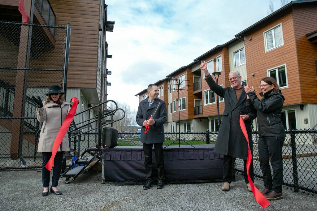 Marysville mayor Jon Nehring, center, cracks a smile after cutting the ceremonial ribbon held by new Housing Hope CEO Donna Moulton, left, outgoing CEO Fred Safstrom and Congresswoman Suzan DelBene, right, during an event at Housing Hopes Twin Lakes Landing II on Wednesday, in Marysville. (Ryan Berry / The Herald)