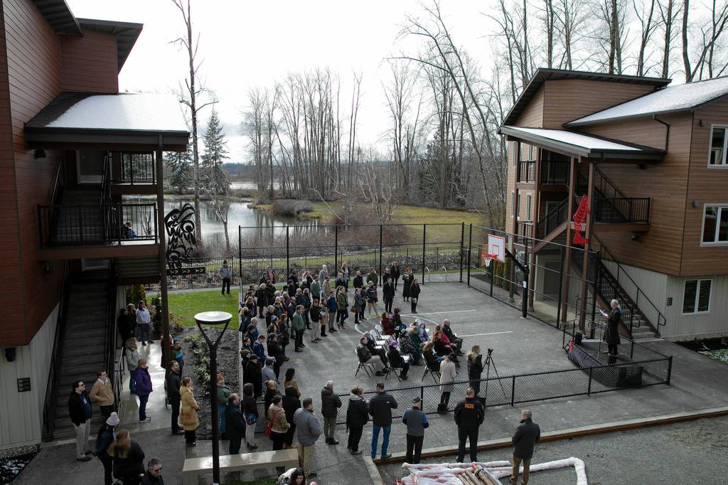 Roughly 100 people gather in a courtyard during a ribbon-cutting ceremony at Housing Hopes Twin Lakes Landing II on Wednesday, in Marysville. (Ryan Berry / The Herald)