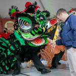 Edmonds Mayor Mike Nelson rewards a lion dancer with a traditional red envelope during a celebration of the Lunar New Year on Jan. 21, in downtown Edmonds. It may become the newest state holiday. (Ryan Berry / Herald file)