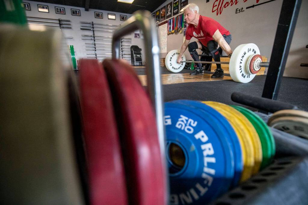 Phil Arnold, 74, practices his lifting techniques at Paramount Strength and Conditioning in Mountlake Terrace, Washington on Thursday, Feb. 2, 2023. The Edmonds resident is 74 and recently retired as an attorney. He took up weightlifting after retirement and recently won a national championship. (Annie Barker / The Herald)
