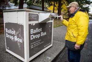 Dennis Michelson pushes his ballot into the drop box outside of Lynnwood City Hall on Nov. 2, 2022 in Lynnwood. (Olivia Vanni / The Herald)