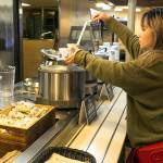 Suzie Zhu serves herself Ivars clam chowder on the Edmonds-Kingston ferry run. The floating food courts offer a variety of Washington products, including sandwiches, beer, wine and ice cream. Ivars chowder and chili is $4.50 to $5.75. (Kevin Clark / The Herald)