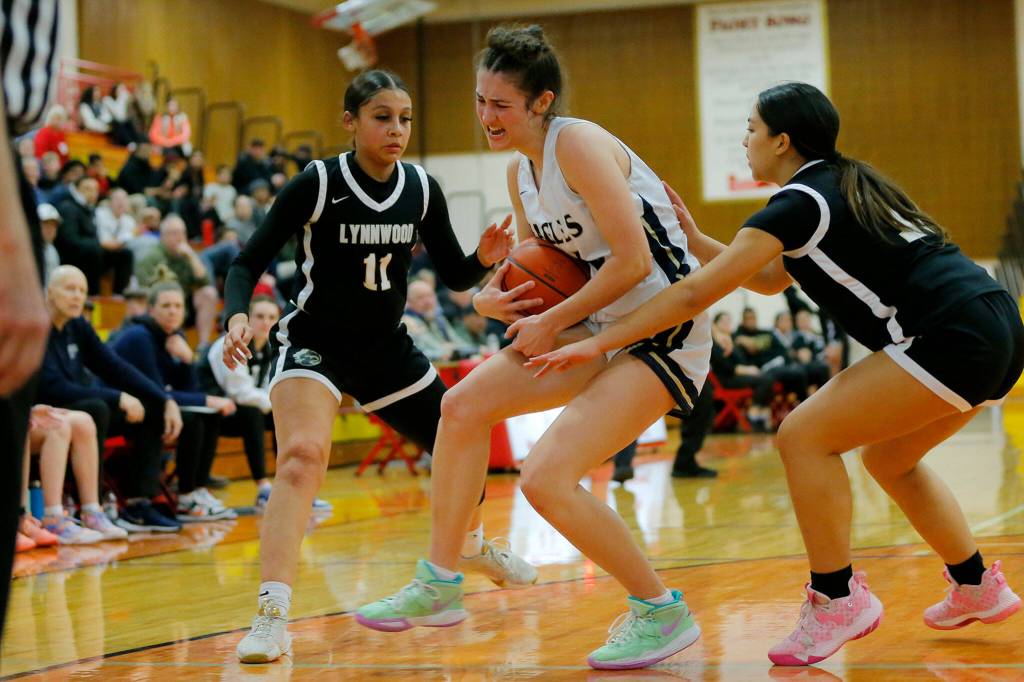 Arlingtons Jenna Villa muscles the ball away from the offense for a rebound against Lynnwood on Tuesday, Feb. 14, 2023, at Marysville Pilchuck High School in Marysville, Washington. (Ryan Berry / The Herald)
